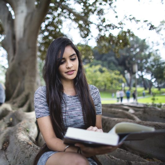 Young woman studying in Aldrich Park at UCI